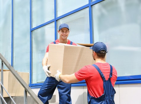 Professional movers packing office equipment